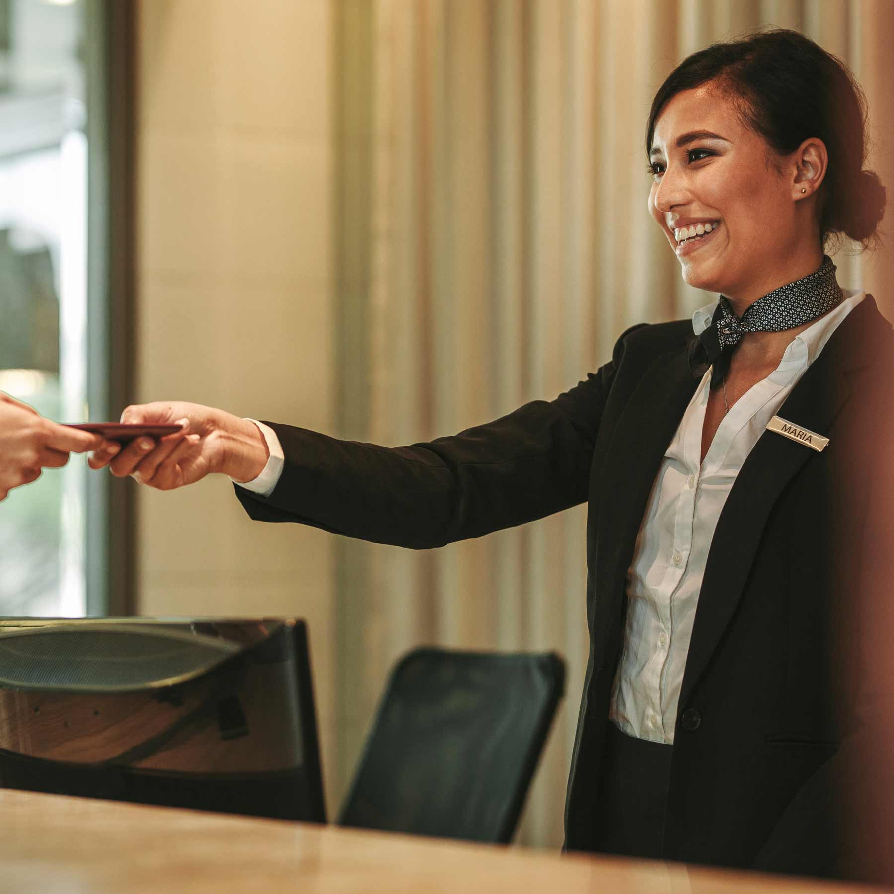 hotel front desk staff handing room key